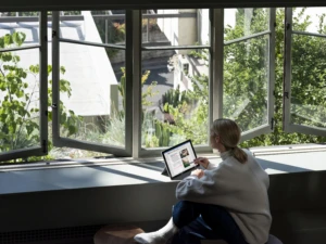 A woman working on a Surface device at home, with security to enable productivity