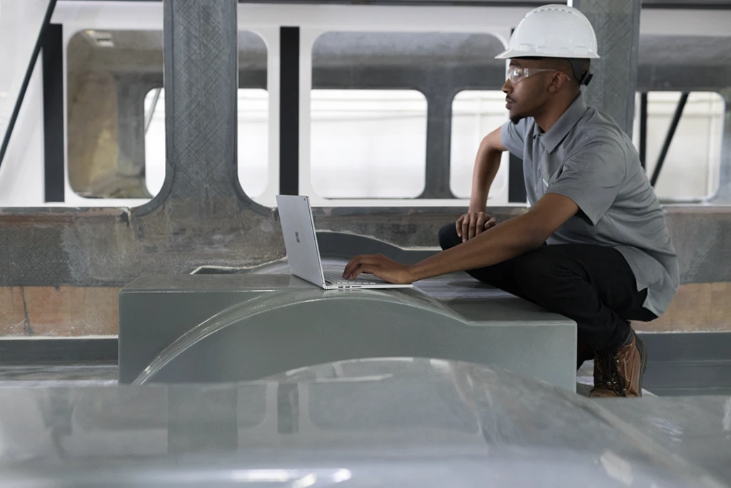 A man in a hardhat with a Surface book in a energy plant. Technology will help us reach net zero targets