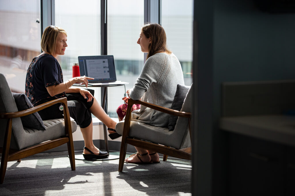 A HR worker and an employee collaborate in common space of an office