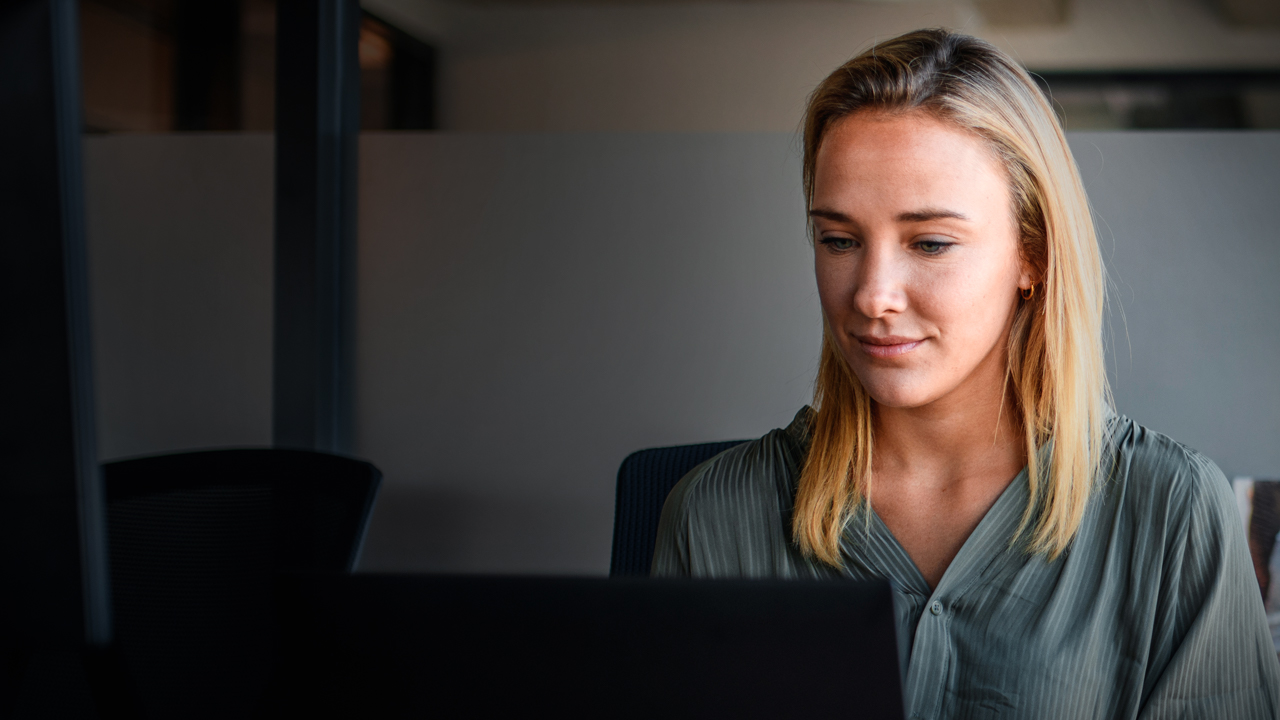 Woman with a face mask working on her laptop