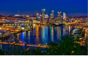 a long bridge over a body of water with a city in the background
