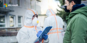 nurse in lab coat and coverups interviewing patient