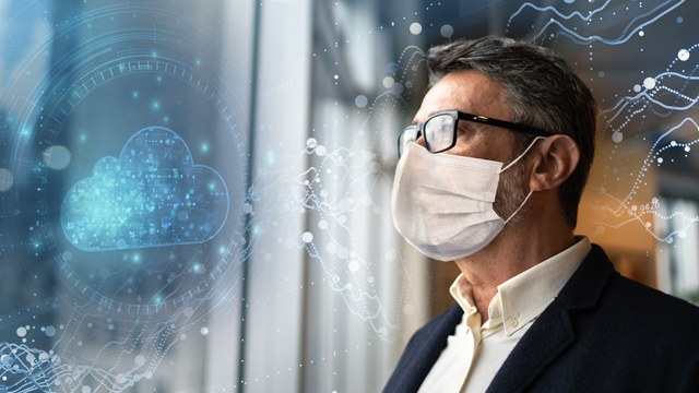 man with a face mask looking out a window
