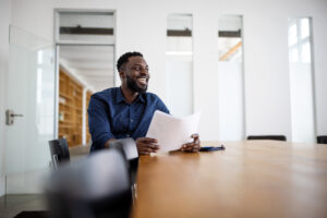 A man sitting at a table holding a paper