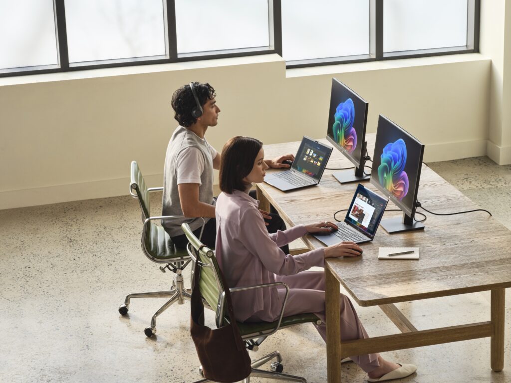two people working on their devices in an office space