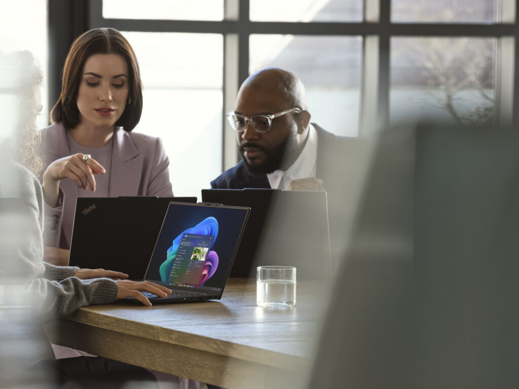A Lenovo device being used by a mixed-gender team in an office space.