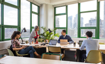 A team sits around a table in an office for a meeting.