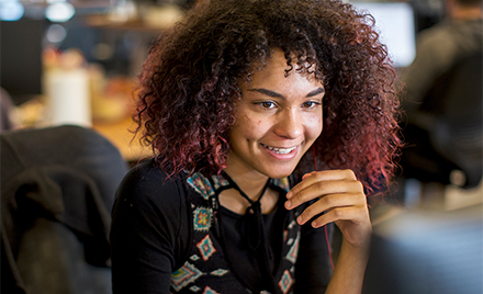 Image of a worker smiling at her computer.