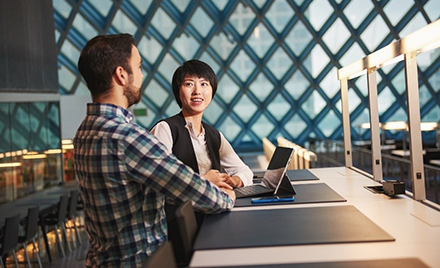 Image of two employees collaborating over a laptop.