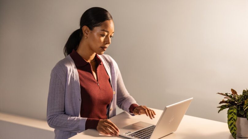 A woman sitting at a desk using a laptop