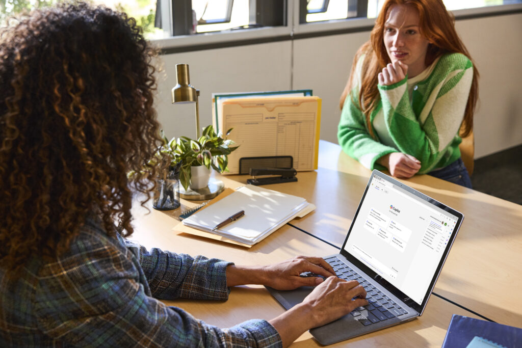 Two students working at a desk.
