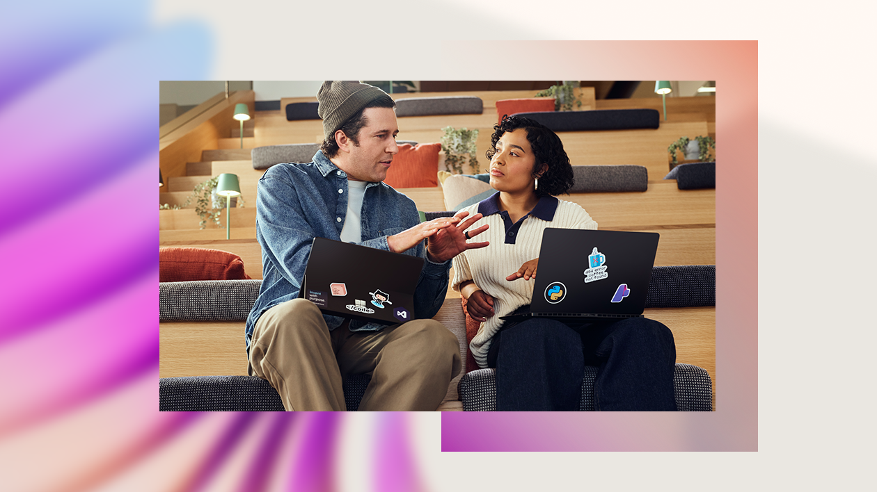 A man and woman sitting on stairs with laptops