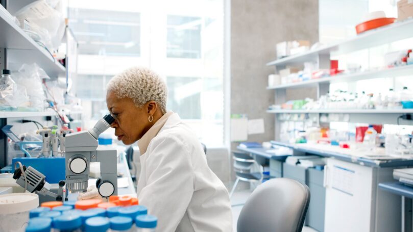 A pharmacist looking in a microscope