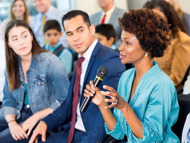woman speaking in a group with a microphone