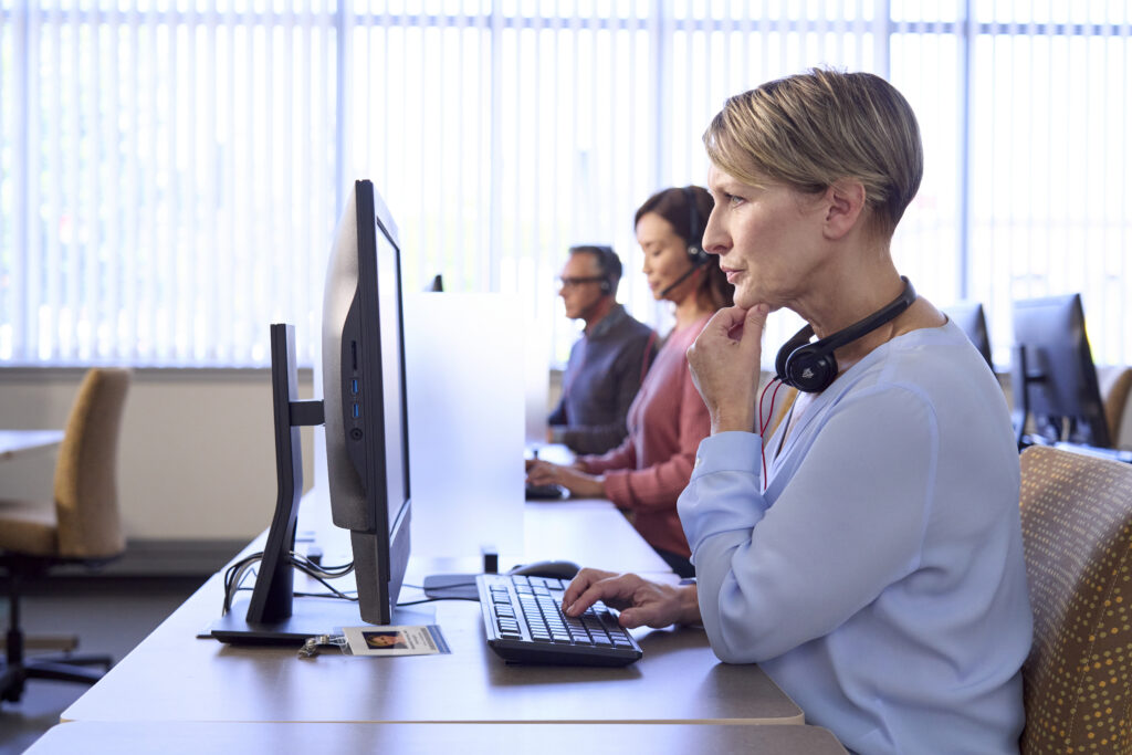 A woman sitting at a desk with a computer