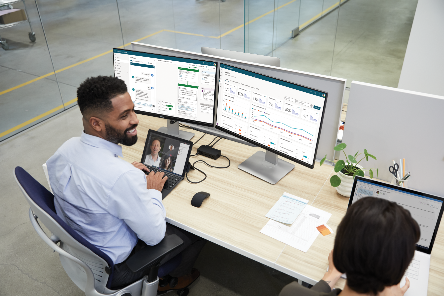 Man creating a Power Virtual Agents bot over two computer screens