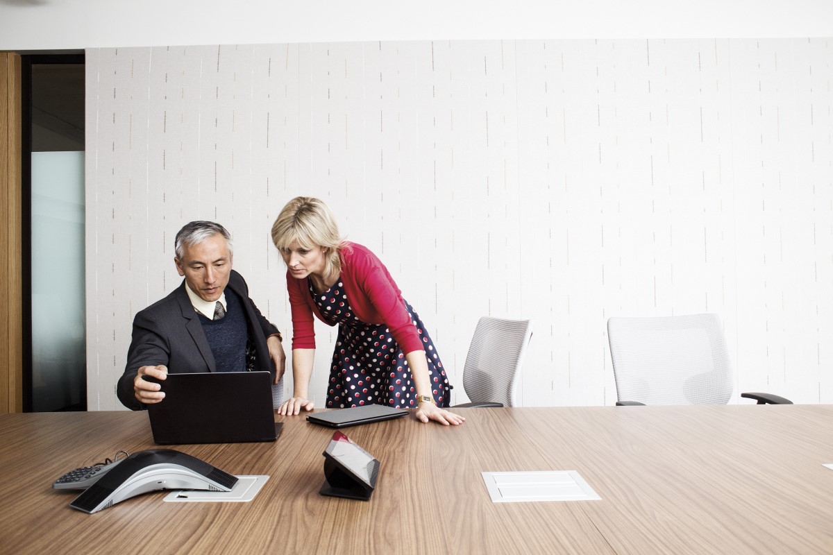 Business man and woman in meeting with laptop.