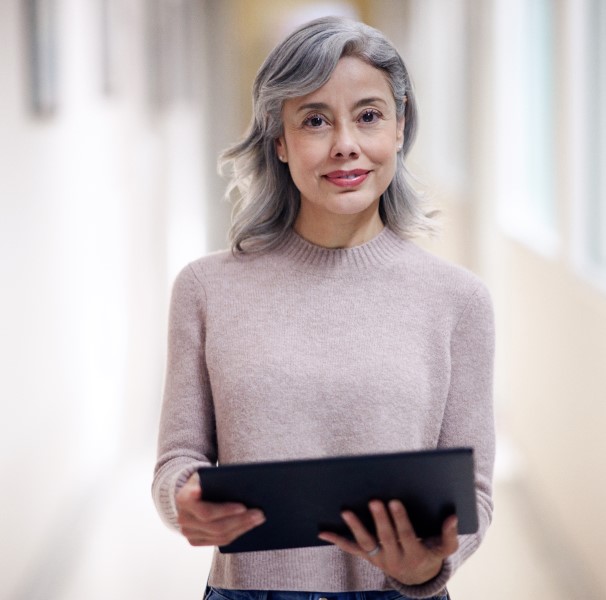 Engaged research director portrait in context of healthcare office, viewing a screen with analytics, insights and results powered by Azure.