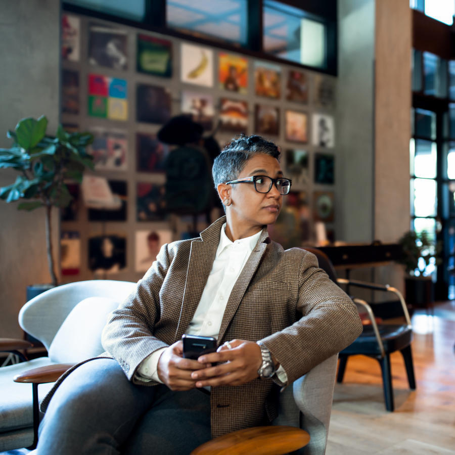 A business woman sitting in a chair in a hotel lobby