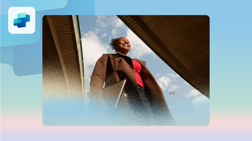 A smiling woman walking to work carrying her laptop