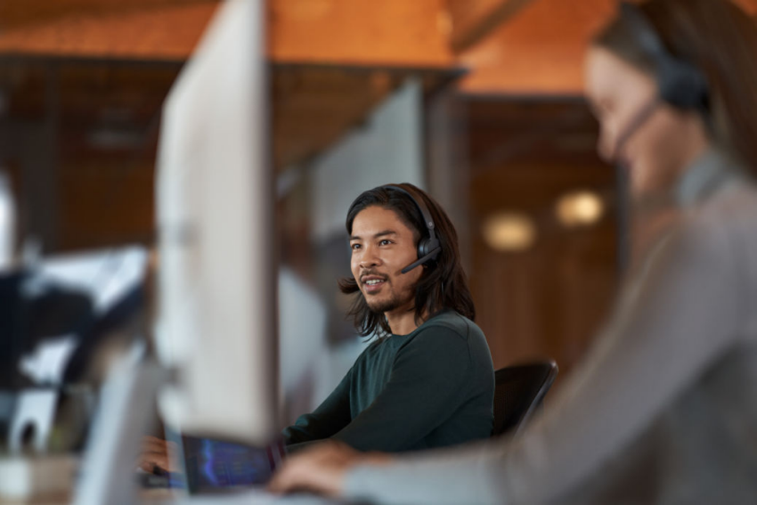 A person wearing a headset working on a desktop