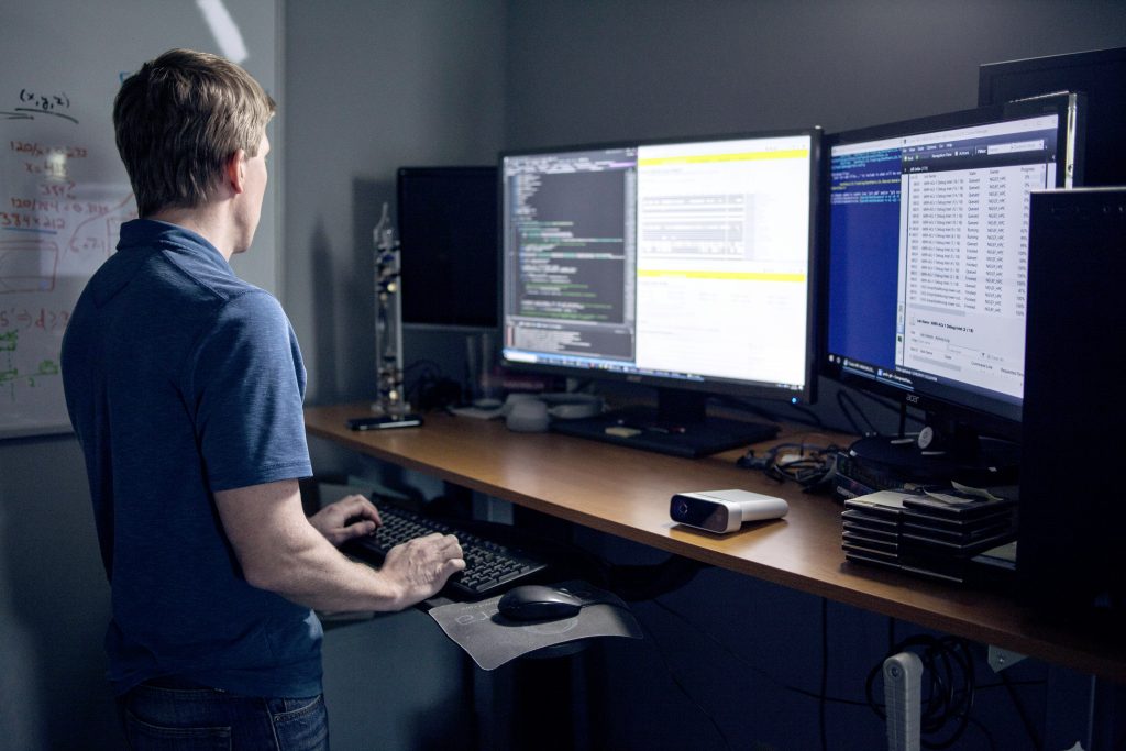 a man sitting at a desk with a computer monitor