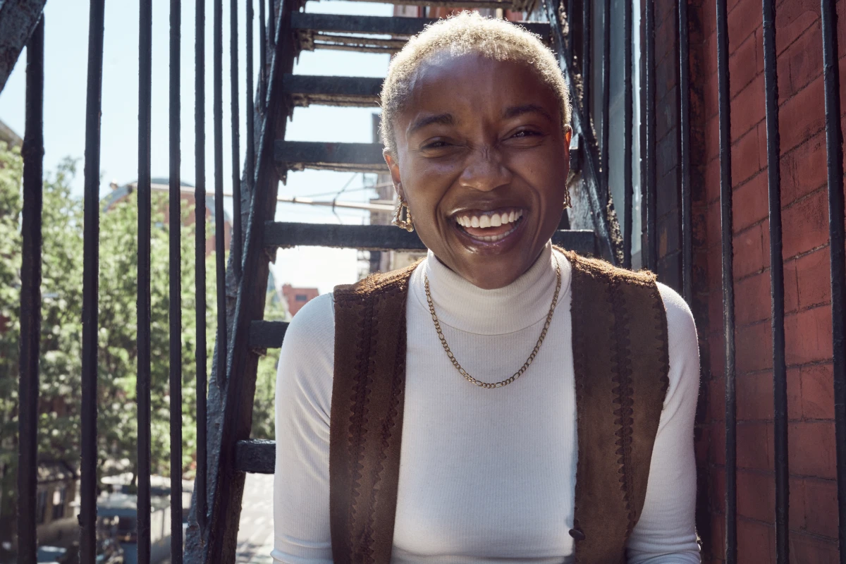 A young adult sitting outside and smiling