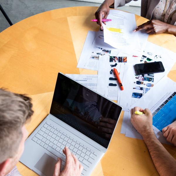 Overhead shot of a group of people sitting at a table using a laptop