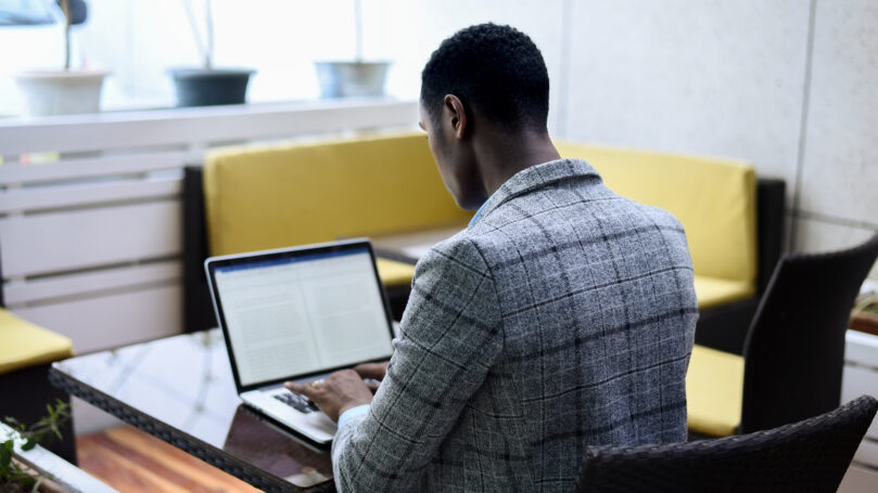 A man sitting at a table using a laptop