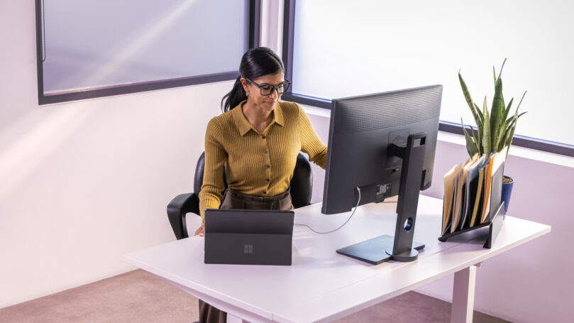 A woman sitting at a desk looking at a computer