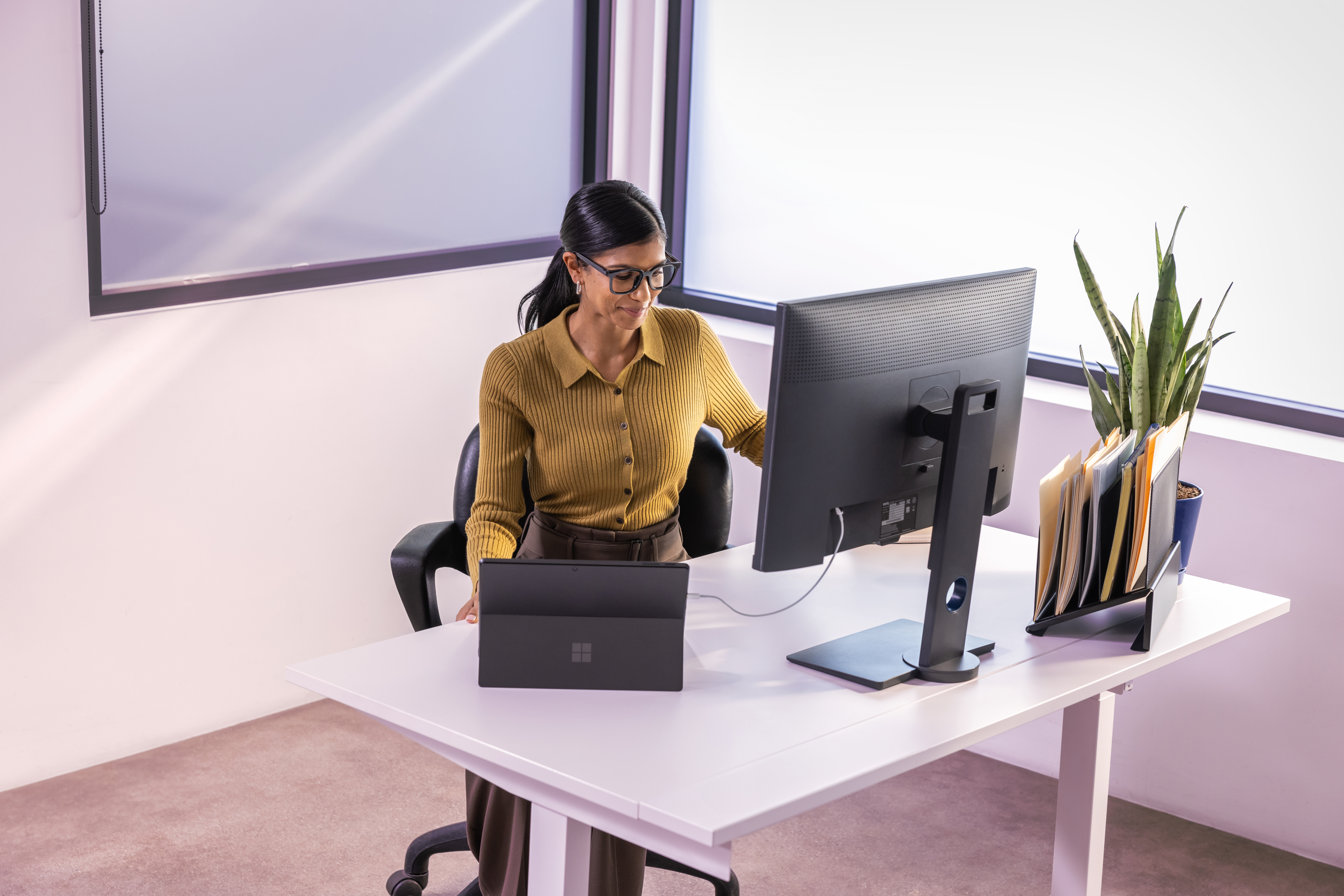A woman sitting at a desk looking at a computer