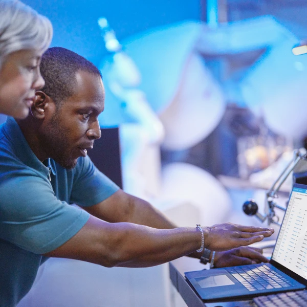 A man and woman looking at a laptop