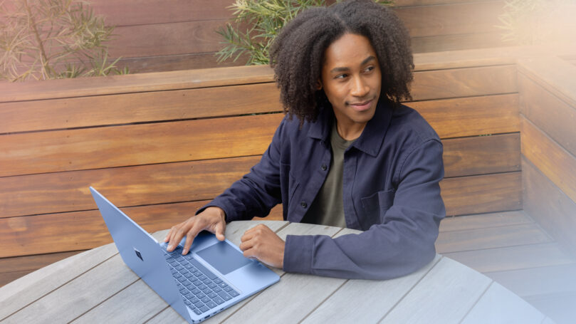 A man sitting at a table with a laptop