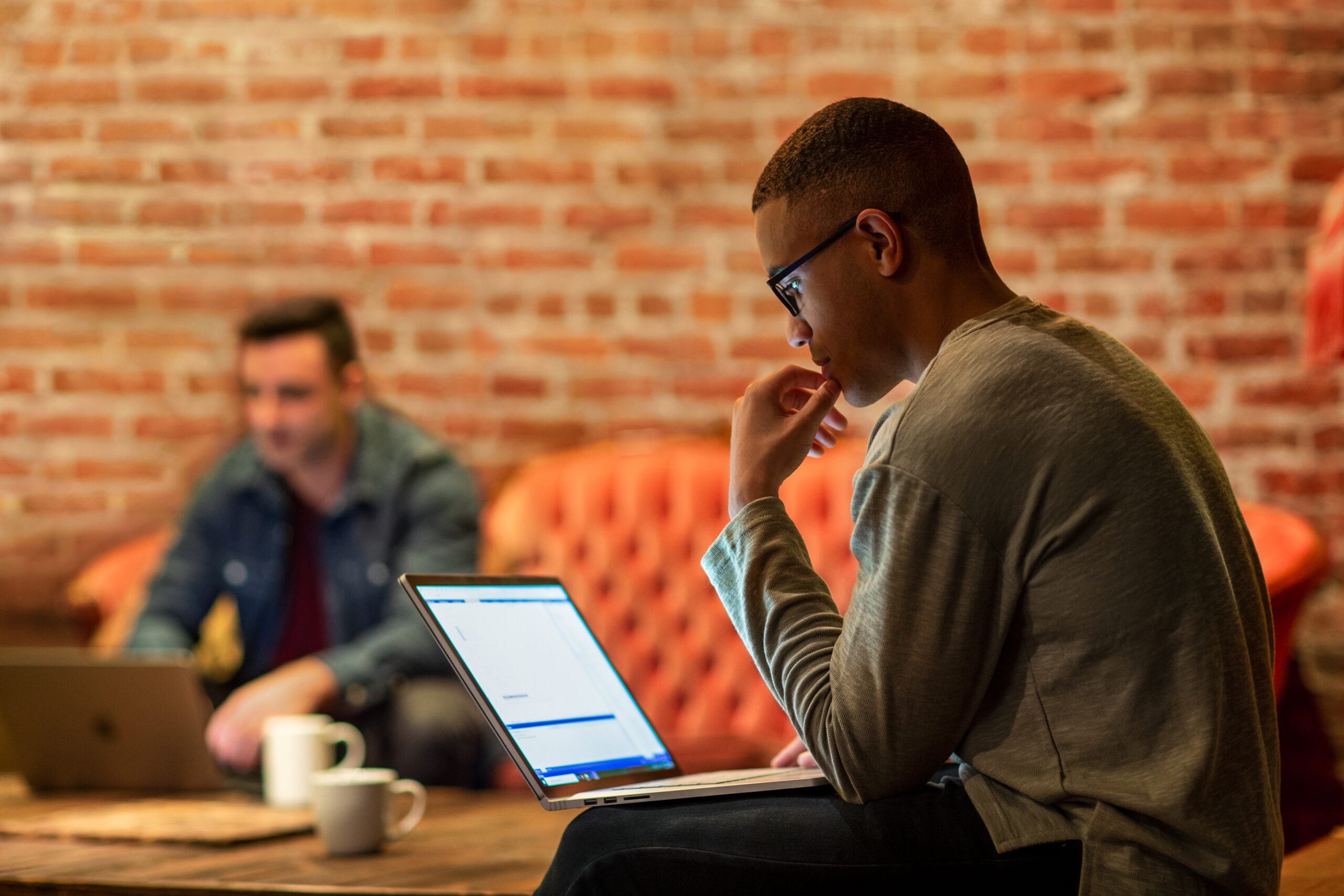 A man sitting on a couch using a laptop