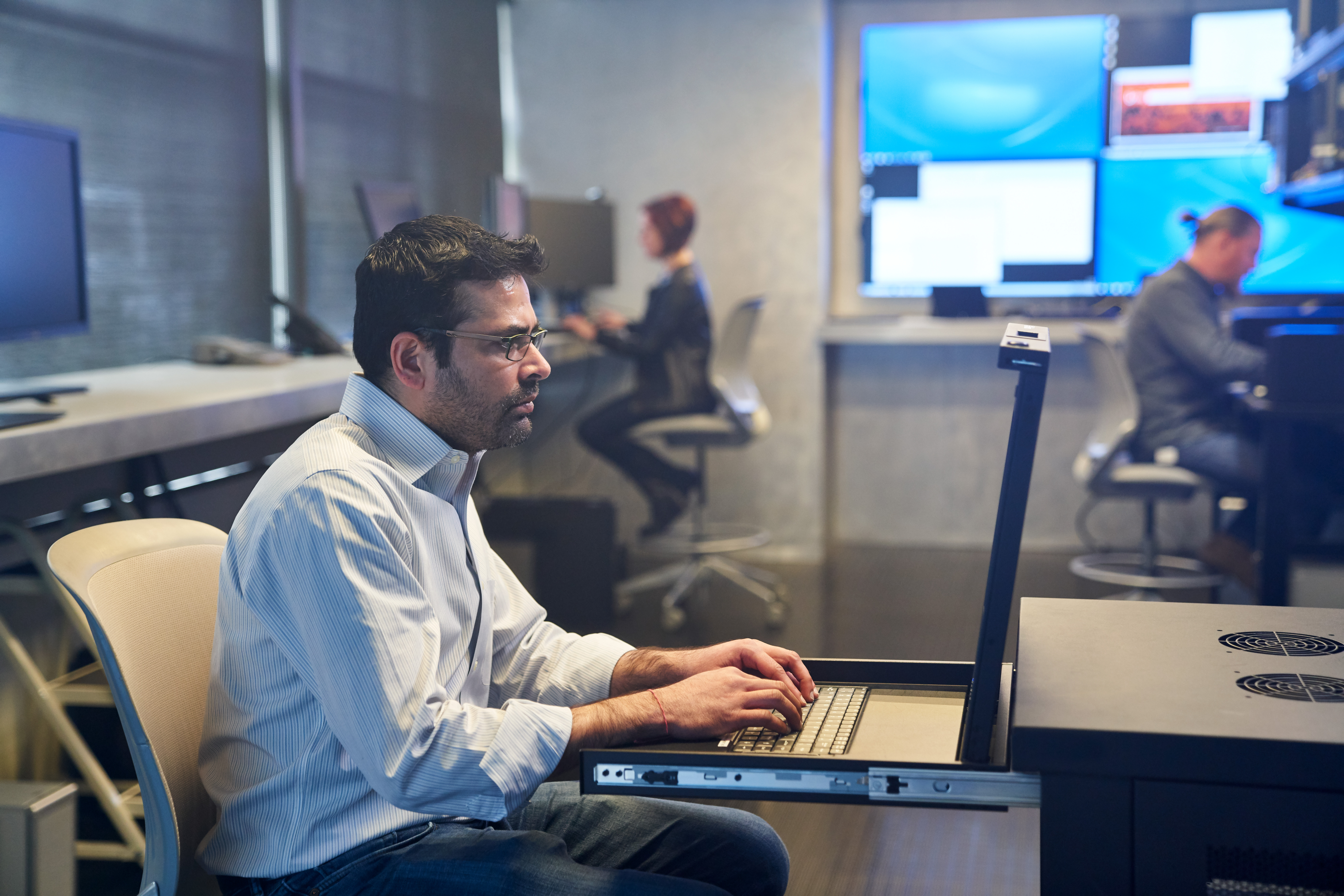 A man sitting at a desk with a laptop