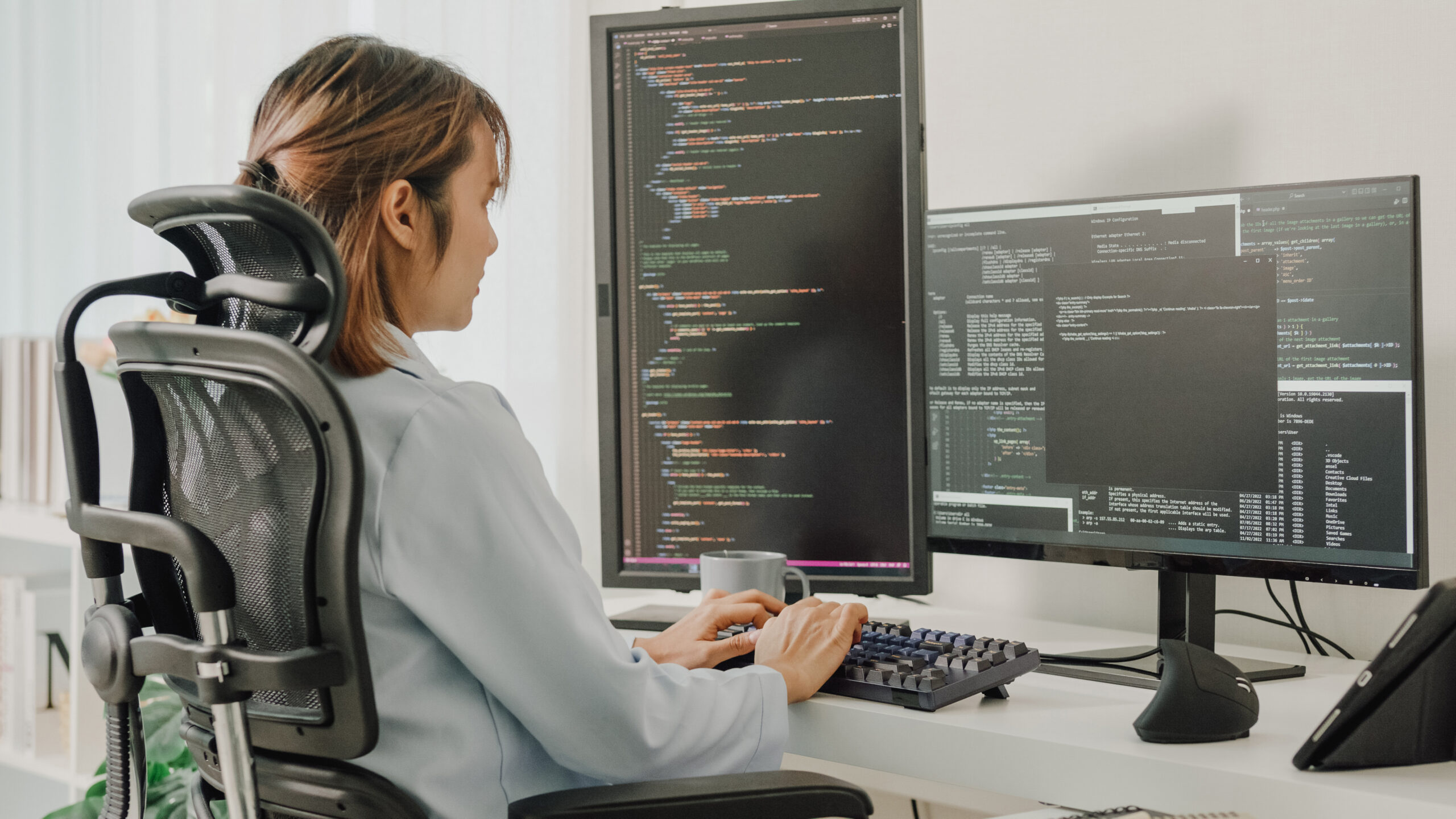 A woman sitting at a desk with a computer screen