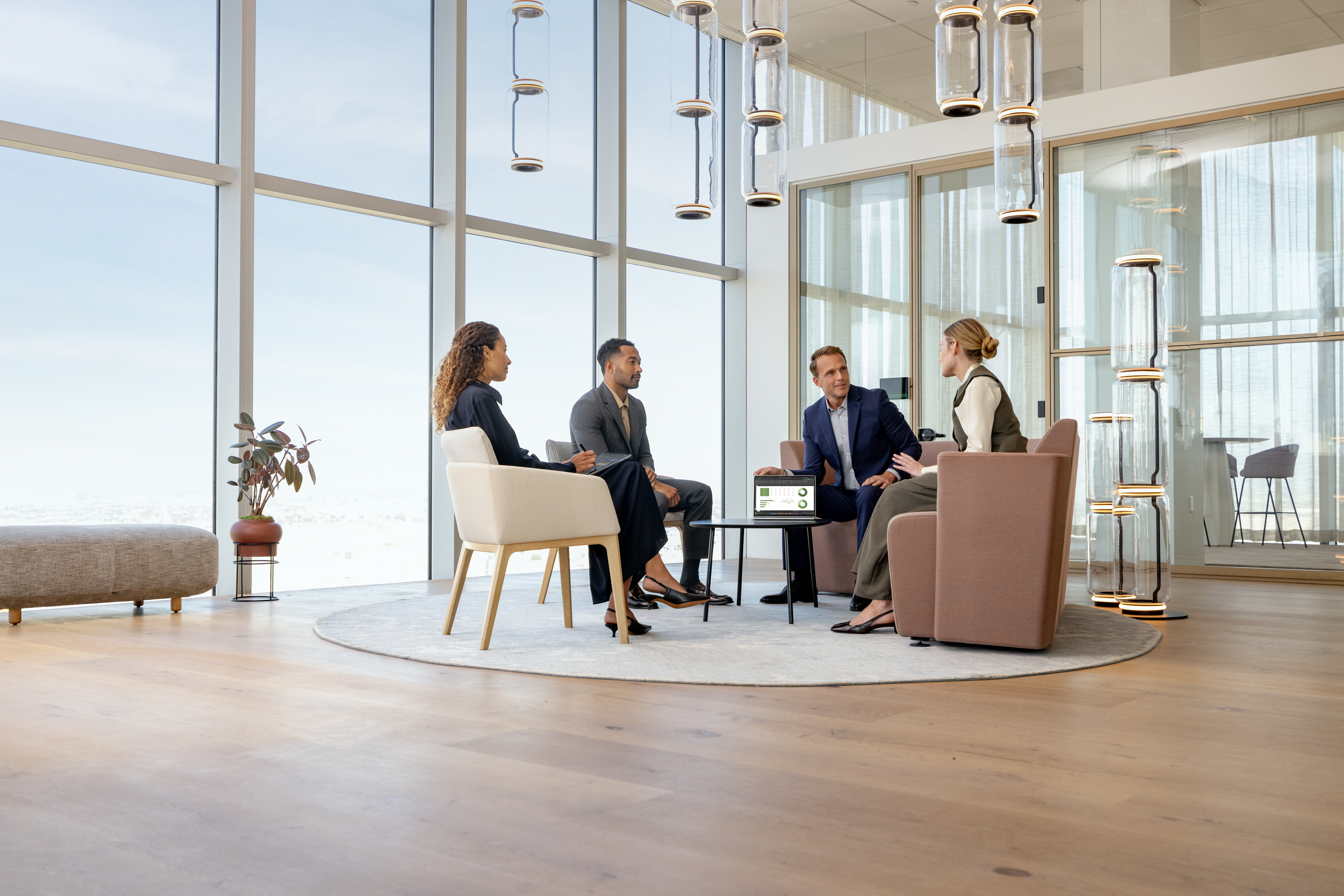 A group of people sitting in chairs in a room with large windows