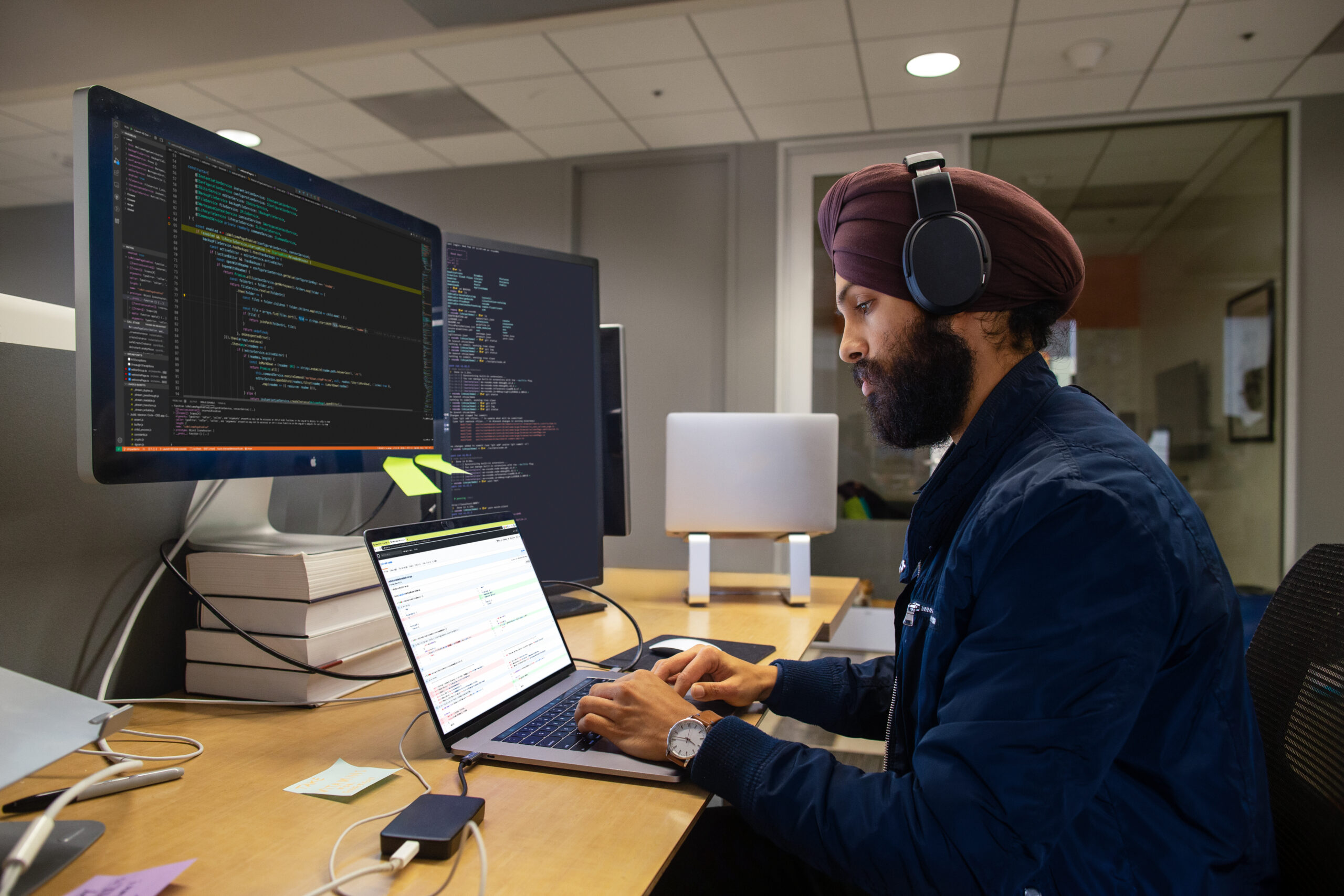 A man wearing headphones and using a laptop
