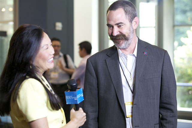 a man in a suit and tie holding a glass of wine