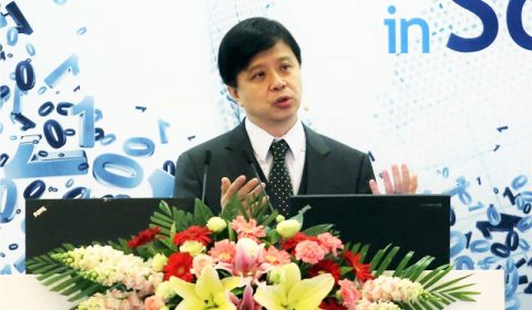 Hsiao-Wuen Hon standing in front of a flower