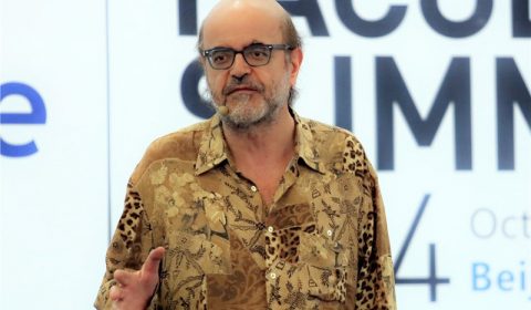 Christos Papadimitriou wearing a uniform and holding a sign