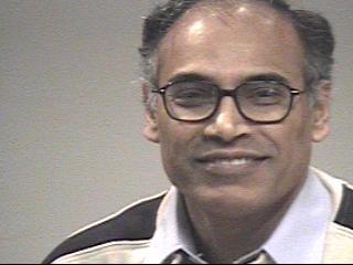 a man wearing glasses and smiling at the camera