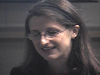 a person wearing glasses and smiling at the camera
