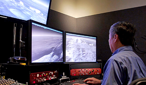 a man sitting at a desk with a computer monitor