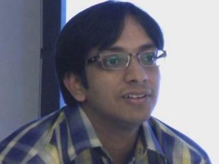 a person wearing glasses and smiling at the camera