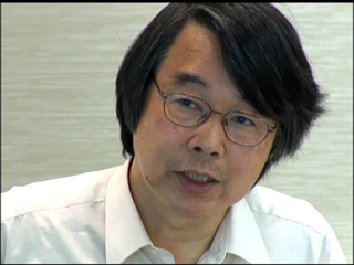 a person wearing glasses and smiling at the camera