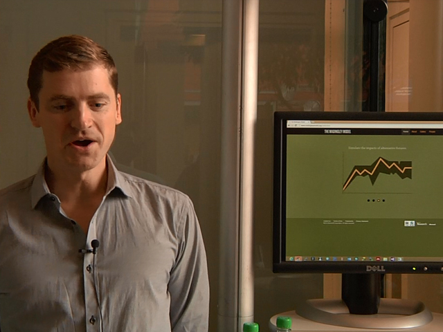 a man standing in front of a monitor