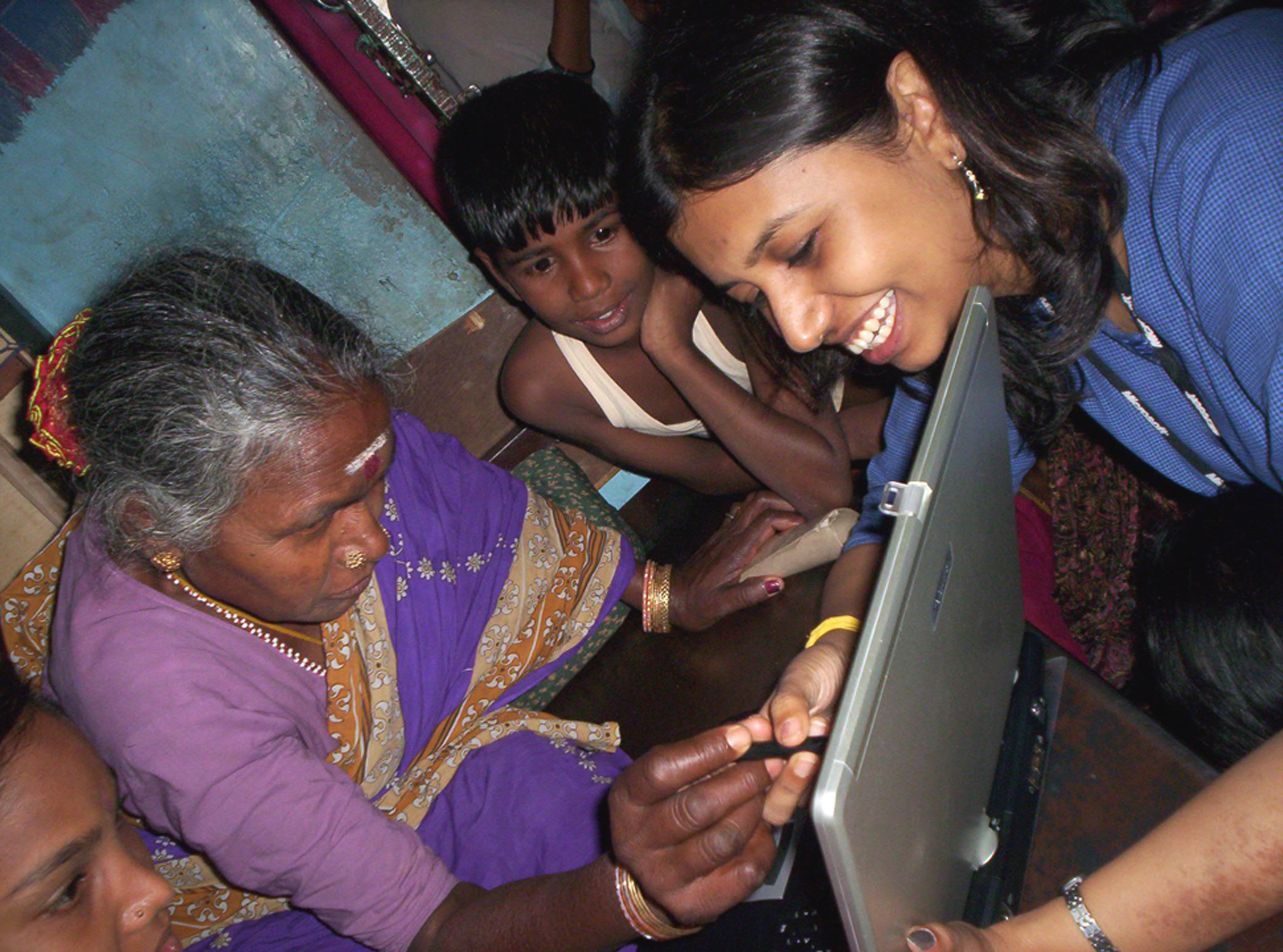 a group of people looking at a laptop