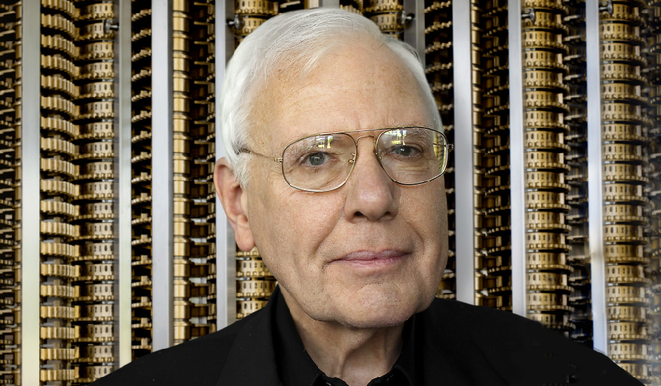 a man wearing glasses and smiling at the camera