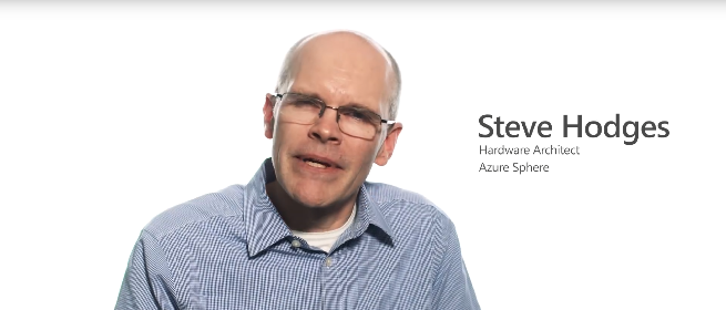 a man wearing glasses and smiling at the camera